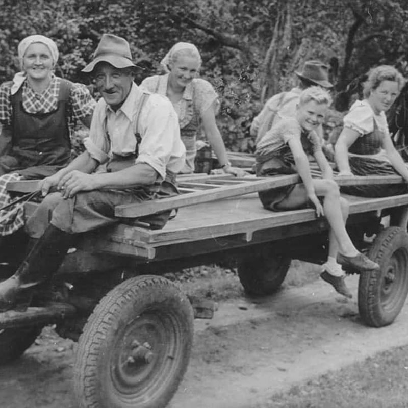 Bauernfamilie sitzt auf Holzwagen